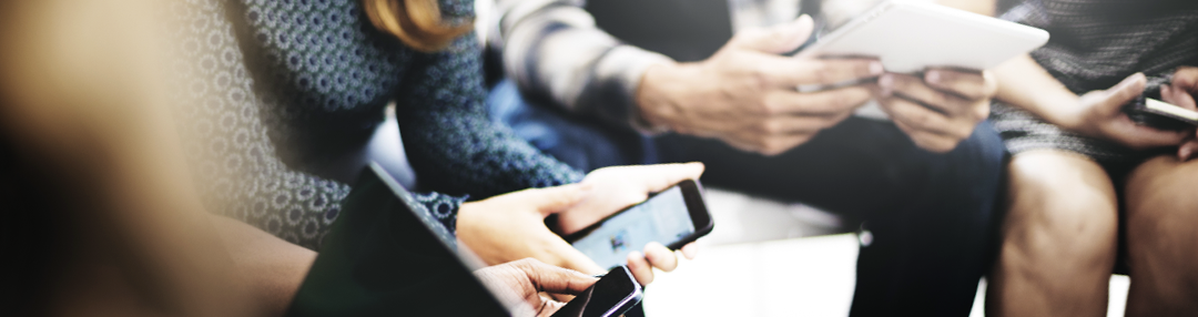 row of people looking at smart devices