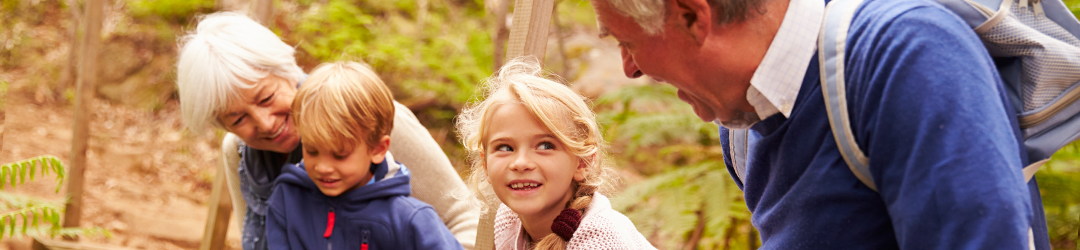 grandparents and grandchildren in woods laughing