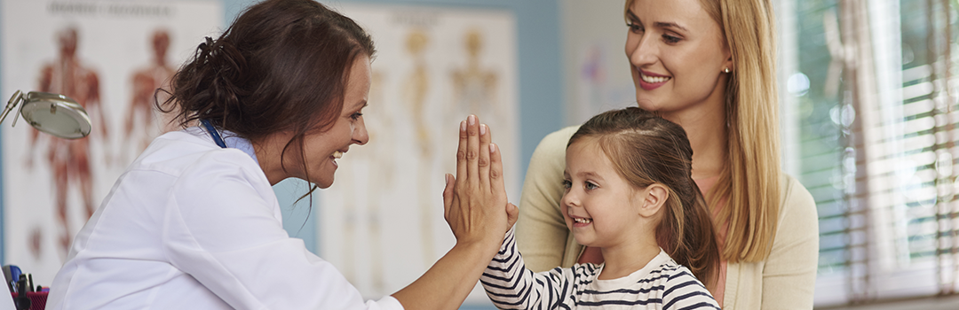 doctor high-fiving child patient with her mother