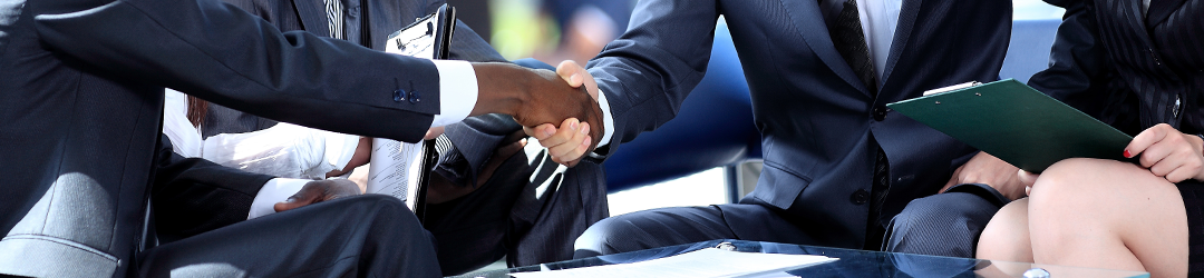 group of professionals sitting and shaking hands